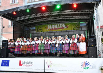 Na scenie odbywa się występ Zespołu Tańca Ludowego Jawor. Występują kobiety w ludowych strojach regionalnych