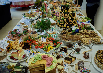 Na stole ciasta i torty biorące udział w konkursie w kategorii „Ciasto jak dawniej” pięknie udekorowane.