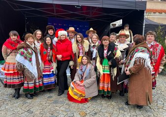Zespół ludowy stoi przed sceną na strym Mieście w Lublinie podczas Jarmarku Bożonarodzeniowego