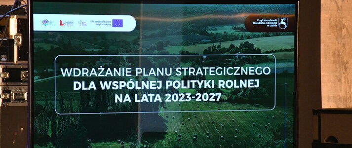 Grafika informująca o konferencji „Wdrażanie Planu Strategicznego dla Wspólnej Polityki Rolnej na lata 2023 – 2027”. Napis widnieje na tle zdjęcia pola na którym leżą bele siana i użytków zielonych, w dali widać las. Wszystko jest w tonacji ciemnozielonej.