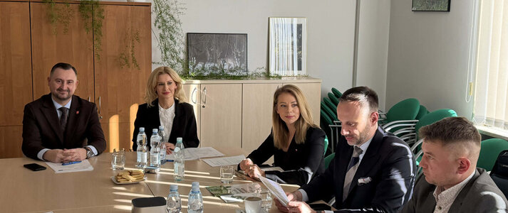 Uczestnicy spotkania Grupy Tematycznej do spraw chmielu siedzą przy stole konferencyjnym, na którym rozłożone są materiały dotyczące omawianych zagadnień