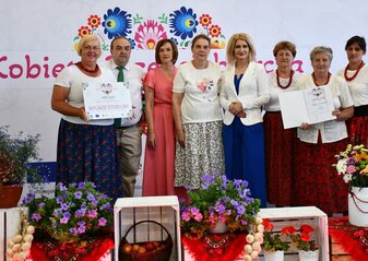Na scenie stoją Panie z Koła które zajęło pierwsze miejsce w półfinale Konkursu Kobieta Przedsiębiorcza. Trzymają czek na wyjazd studyjny który jest prezentem za zajęcie pierwsze miejsca. Wraz z nimi jest Pani Ewa Szałachwiej, Dyrektor Departamentu Rolnictwa i Rozwoju Obszarów Wiejskich