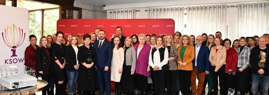 Uczestnicy konferencji stoją w sali na tle ścianki promocyjnej województwa lubelskiego