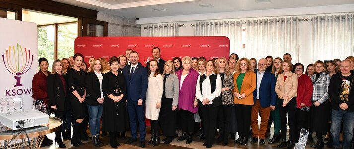 Uczestnicy konferencji stoją w sali na tle ścianki promocyjnej województwa lubelskiego