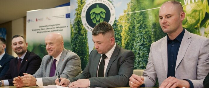 Za stołem siedzi czterech mężczyzn. Wśród nich jest marszałek województwa lubelskiego Jarosław Stawiarski oraz wicemarszałek Marek Wojciechowski oraz dwóch przedstawicieli Stowarzyszenia Polskich Plantatorów Chmielu w Wilkowie