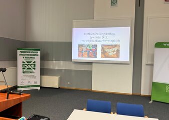 Sala konferencyjna Podkarpackiego Ośrodka Doradztwa Rolniczego w Boguchwale z wyświetloną tytułową strona prezentacji pod tytułem Krótkie łańcuchy dostaw żywności, rozwojem obszarów wiejskich