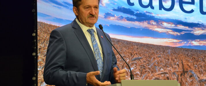 Członek Zarządu Województwa Lubelskiego Zdzisław Szwed przemawiający podczas uroczystego wręczenia umów parterom Krajowej Sieci Obszarów Wiejskich. W tle ścianka przedstawiająca zachód słońca nad polem z dojrzałym zbożem, na górze napis lubelskie.