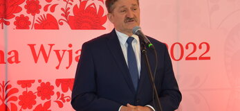 Członek Zarządu Województwa Lubelskiego Zdzisław Szwed przemawiający podczas półfinału konkursu Kobieta Gospodarna Wyjątkowa. W tle logo konkursu: czerwone serce z łowickich wzorów, pośrodku biały pas z napisem Kobieta Gospodarna Wyjątkowa