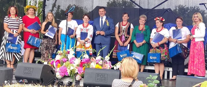 Na scenie stoi 11 osób: uczestniczki konkursu Pieczywo z dodatkiem ziół trzymające w rękach teczki i torby koloru niebieskiego. Wśród stojących osób znajduje się Członek Zarządu Województwa Lubelskiego Zdzisław Szwed oraz Dyrektor Departamentu Rolnictwa i Rozwoju Obszarów Wiejskich Ewa Szałachwiej