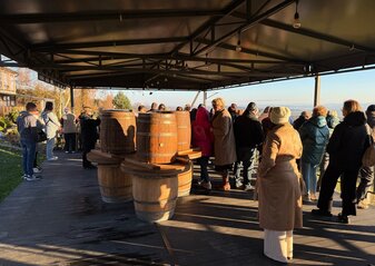 Grupa uczestników wyjazdu studyjnego do województwa podkarpackiego znajduje się w wiacie Winnicy Widokowej, w której ustawione są dębowe beczki na wino