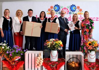 Koło Gospodyń Wiejskich, które zajęło trzecie miejsce w półfinale konkursu Kobieta Przedsiębiorcza stoi na scenie udekorowanej kwiatami