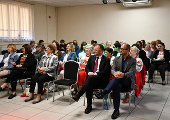 Uczestnicy biorący udział w szkoleniu siedzą w rzędach na krzesłach w sali konferencyjnej z uwagą słuchają prelekcji