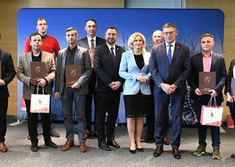 Grupa osób stoi w sali konferencyjnej. Trzymają w dłoniach teczki. Są to osoby, które zostały powołane do Grupy Tematycznej do spraw rolnictwa i Rozwoju Obszarów Wiejskich