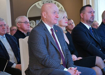 Podczas konferencji „Wsparcie pszczelarstwa w województwie lubelskim” na widowni siedzą uczestnicy i słuchają wykładu. Na pierwszym planie marszałek województwa lubelskiego Jarosław Stawiarski