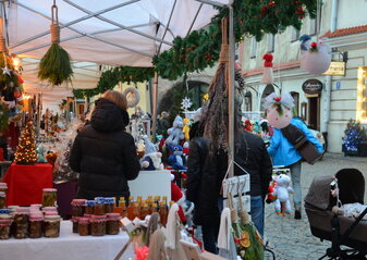 Stoiska na jarmarku Bożonarodzeniowym w Lublinie. Na stoisku są miody i ozdoby świąteczne